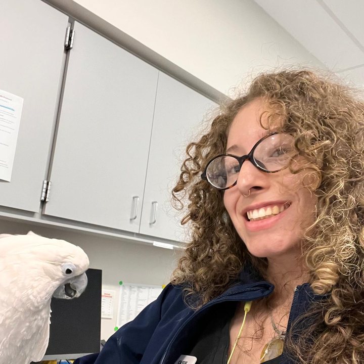 Suari smiling at a white cockatoo